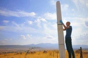 man next to bladeless wind turbine