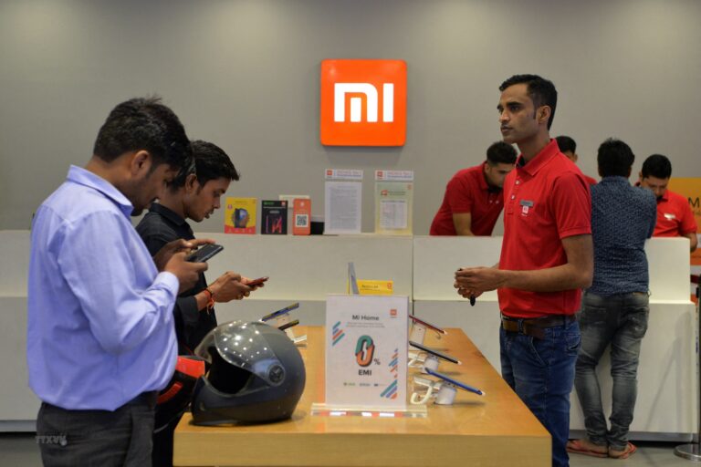 Customers inspect smartphones made by Xiaomi at a Mi store in Gurgaon
