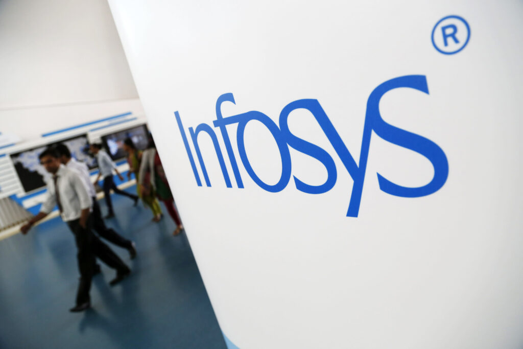 Employees walk past an Infosys Ltd. logo at the company's campus in Electronics City in Bangalore, India