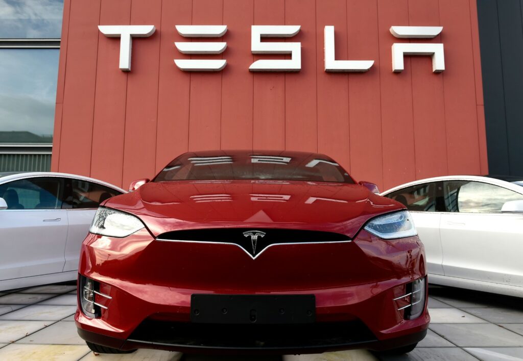 Red Tesla car outside showroom