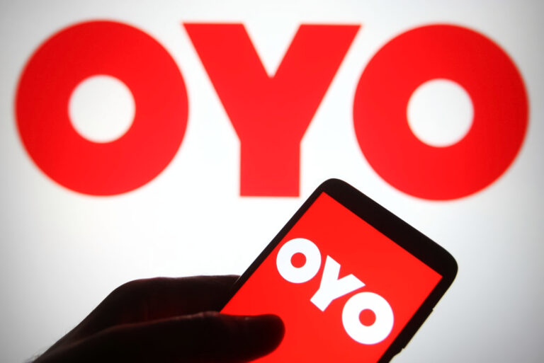 OYO logo seen on a smartphone and a pc screen