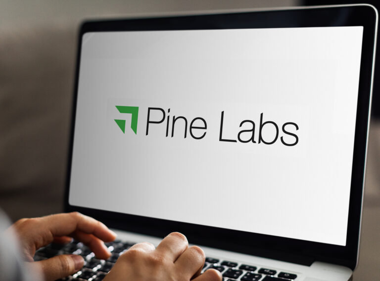 Pine Labs logo on laptop screen