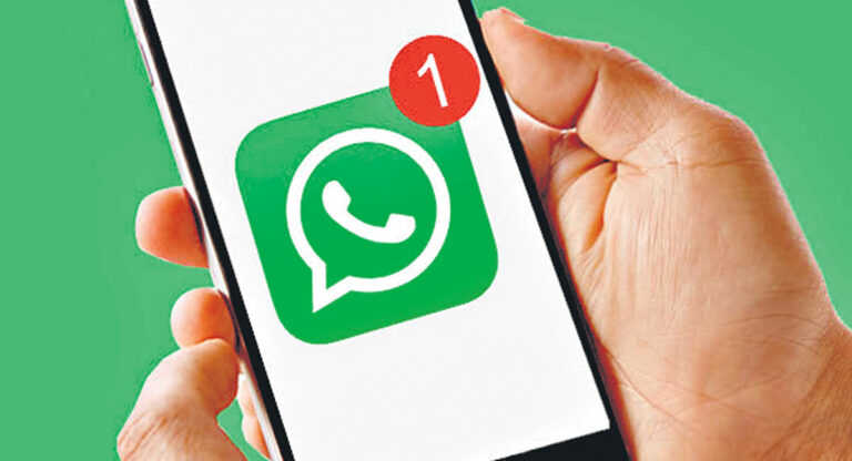 Someone holding a phone depicting WhatsApp logo with a notification sign