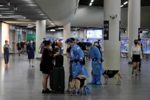 A police officer in a protective suit checks on a commuter at a subway station, after the lockdown placed to curb the coronavirus disease (COVID-19) outbreak was lifted in Shanghai, China June 2, 2022.