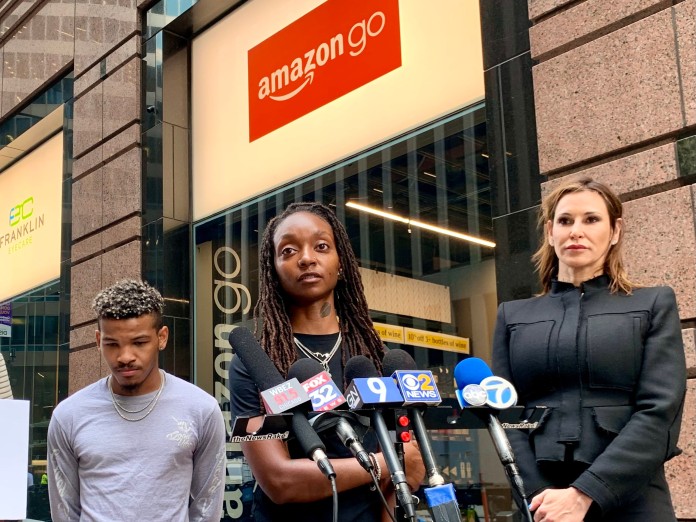 Attorney Tamara Holder, right, speaks as Amazon worker Tori Davis listens during a news conference