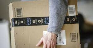 A person holding a box depicting prime sticker