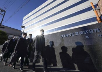 Officials from the transport ministry enter Daihatsu Motor's headquarters in Ikeda