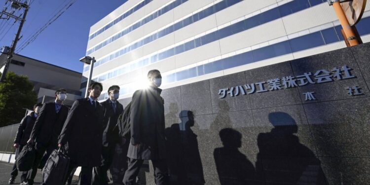Officials from the transport ministry enter Daihatsu Motor's headquarters in Ikeda