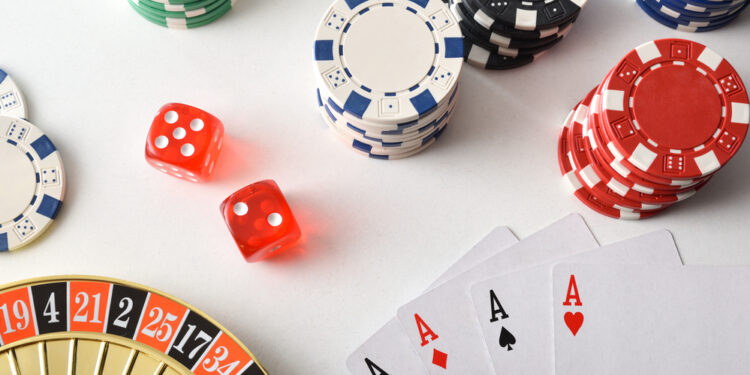Casino games background isolated on white table with playing cards, betting chips and dice for playing various games of chance. Top view.