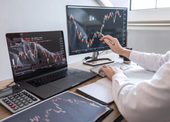 Stock exchange market concept, Business investor trading or stock brokers having a planning and analyzing with display screen and pointing on the data presented and deal on a stock exchange.
