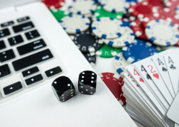 Online poker with laptop playing card chips and dice. Online gambling casino concept