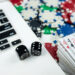 Online poker with laptop playing card chips and dice. Online gambling casino concept