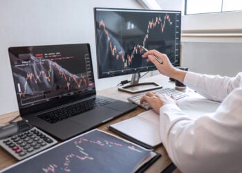 Stock exchange market concept, Business investor trading or stock brokers having a planning and analyzing with display screen and pointing on the data presented and deal on a stock exchange.