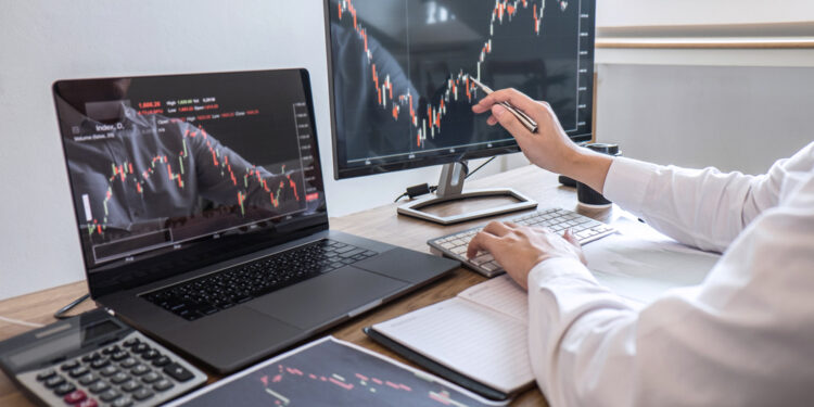 Stock exchange market concept, Business investor trading or stock brokers having a planning and analyzing with display screen and pointing on the data presented and deal on a stock exchange.