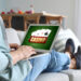 Young man with laptop playing in casino online at home