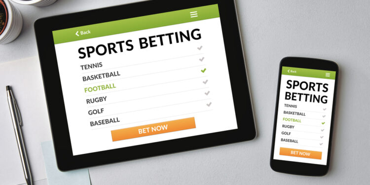 Sports betting concept on tablet and smartphone screen over gray table. All screen content is designed by me. Flat lay